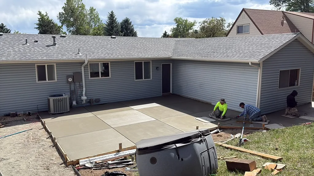 Backyard concrete patio with control joints being finished by the Wilson crew