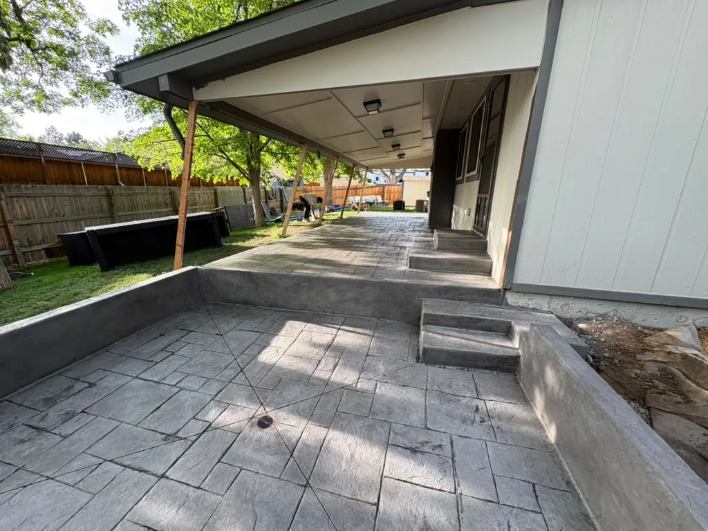 Gray ashlar stamped concrete patio with step-down and poured walls